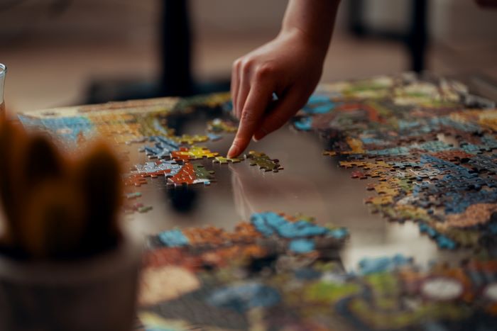 a hand putting puzzles together