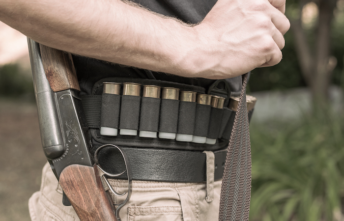 man with ammunition belt and a rifle