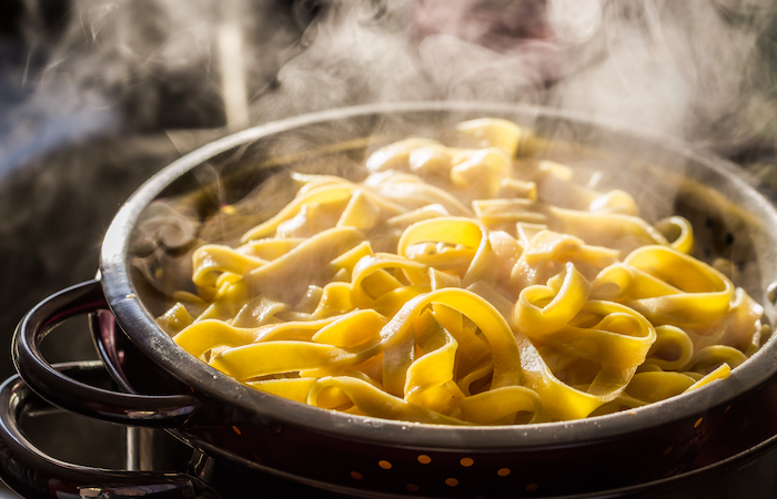 putting linguini noodles through a strainer