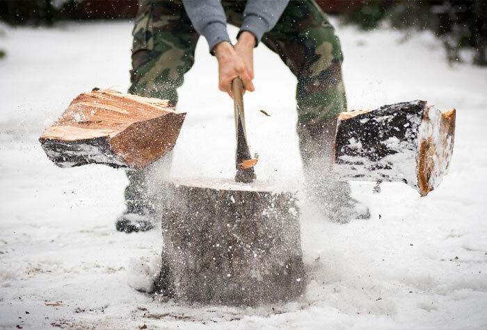 man chopping wood in the snow