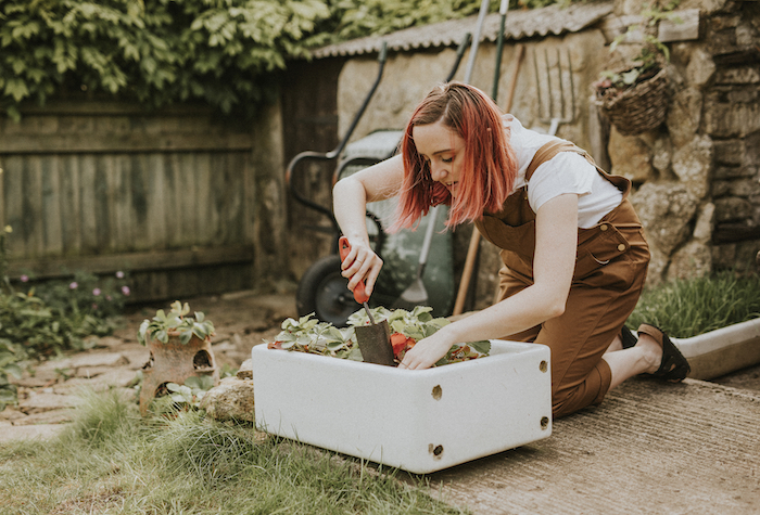Woman planting in a small home garden box.