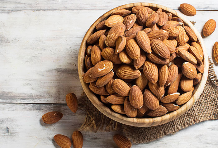 Bowlful of almonds sitting on a table.