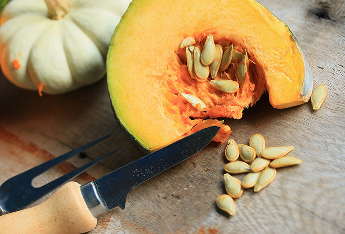 A cut open squash with its seeds spilling out.
