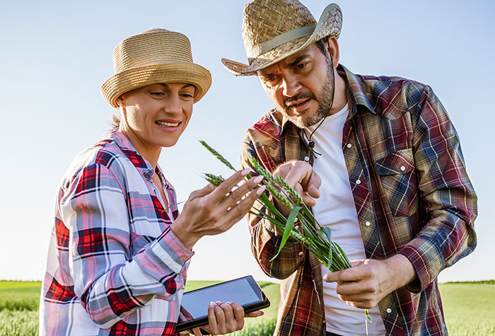 Teacher showing a student outdoors about a plant. 