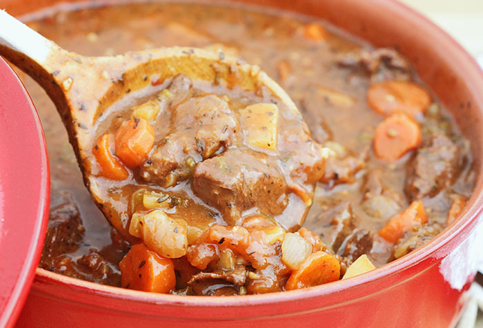 Stirring a large potful of stew.