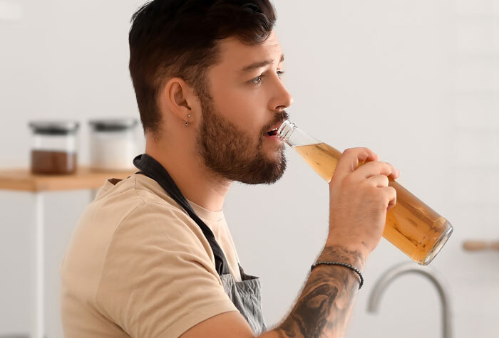 A man drinking a bottle of home-brewed beer.